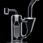 Clear glass dab rig with intricate percolator and quartz nail.