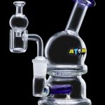 Clear glass bubbler with blue accents and a quartz dab rig attachment, branded "ATOMIC."