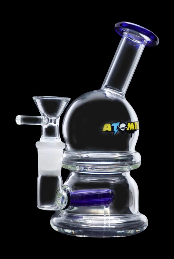 Clear glass bubbler with blue accents and "ATOMIC" lettering, used for smoking cannabis.