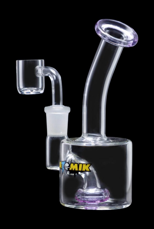 The Atomik Little Dipper Dab Rig appears in a studio shot, highlighting its clear glass construction and compact 5.25-inch size.