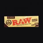 A close-up of the "RAW "Cut Corners" Single Wide Rolling Papers" package, showcasing the brand logo and text on its colorful surface.
