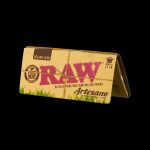 Pack of RAW Organic Hemp rolling papers and Artesano tips against a black background.