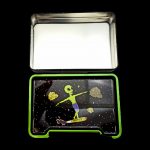 Open metal tin with a space-themed design featuring an alien surfing on a cannabis bud.