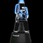 Pulsar vaporizer with a blue glass water pipe attachment, displayed against a black background.