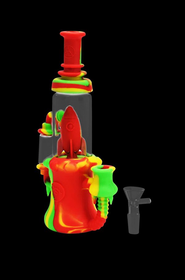 Red and green silicone water pipe with a rocket ship design, and a glass downstem beside it.