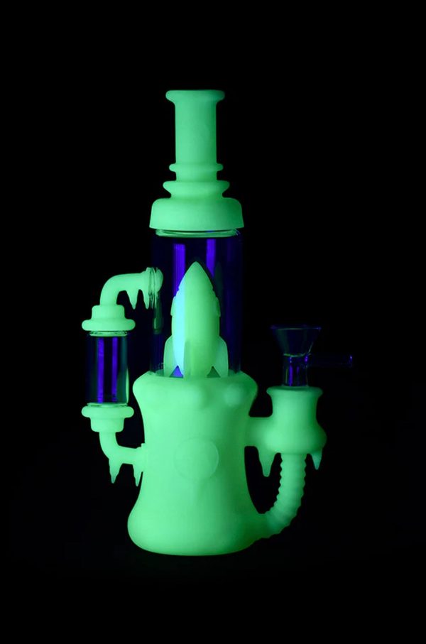 Glowing green glass water pipe (rig) with purple accents against a black background.