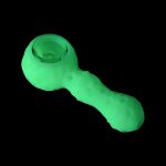 Glowing green silicone cannabis pipe isolated on black.