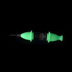 Glowing green dab syringe with glass tip and intricate internal structure.
