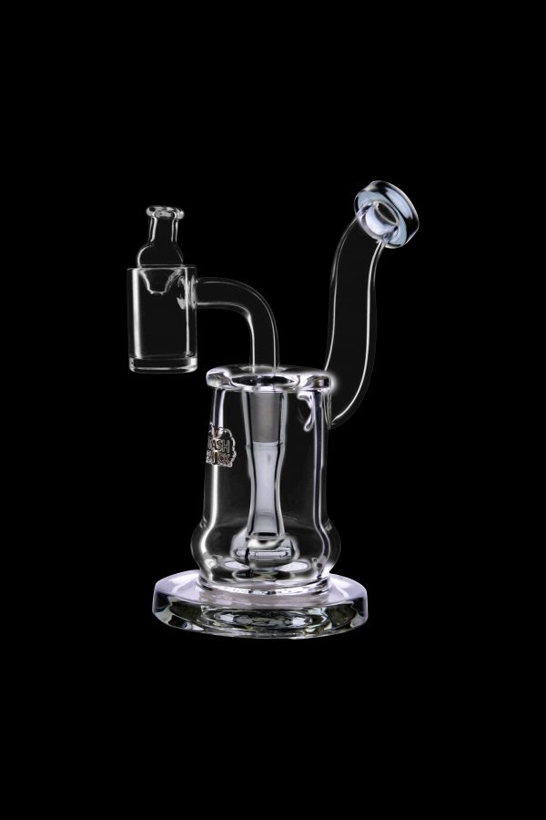 Clear glass dab rig with a quartz banger and intricate swirling design, isolated on a black background.
