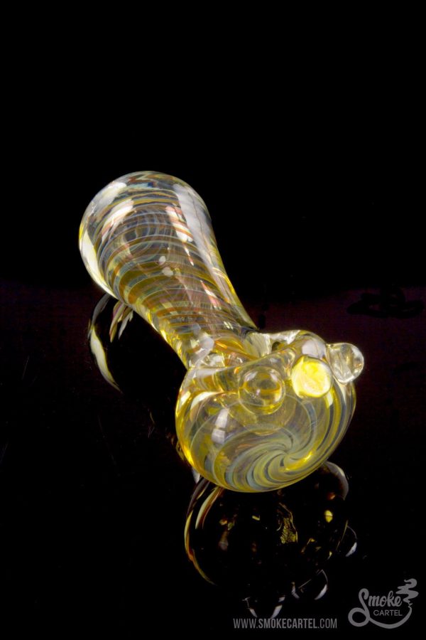 A side view of the Gold Fumed Spoon Pipe - Midas, featuring gold accents and a curved bowl against a dark backdrop.