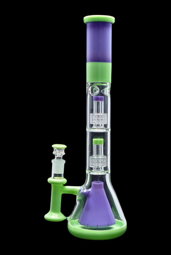 A vibrant green and purple glass water pipe (bong) with intricate percolators, accompanied by a separate glass downstem.