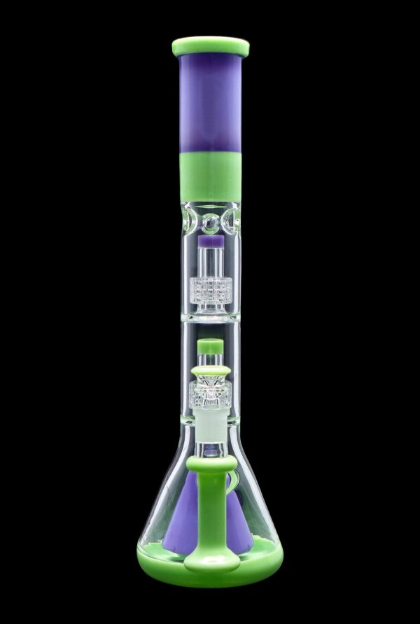 Green and purple glass bong with intricate percolators, isolated on a black background.