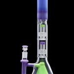 A vibrant, multi-chambered glass bong with a green base, purple midsection, and blue mouthpiece, accompanied by a separate glass pipe.