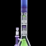 A vibrant, multi-chambered glass water pipe (bong) with purple and green accents, displayed with a separate glass piece.
