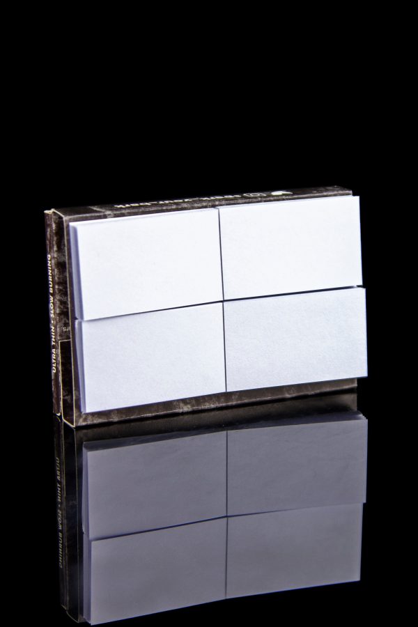 Stack of pre-rolled hemp filter tips with a mirrored reflection on a black surface.