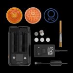 A studio shot of the Storz & Bickel Mighty Portable Vaporizer alongside its accessories and charging cable on a black background.