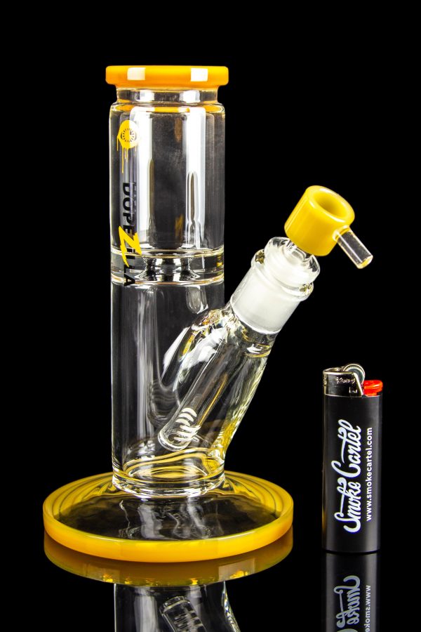 A clear glass bong with yellow accents, a glass bowl, and a lighter, displayed on a reflective surface.