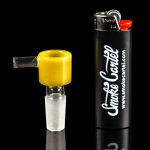 Yellow glass cannabis bowl next to a black lighter with “Smoke Cartel” branding.