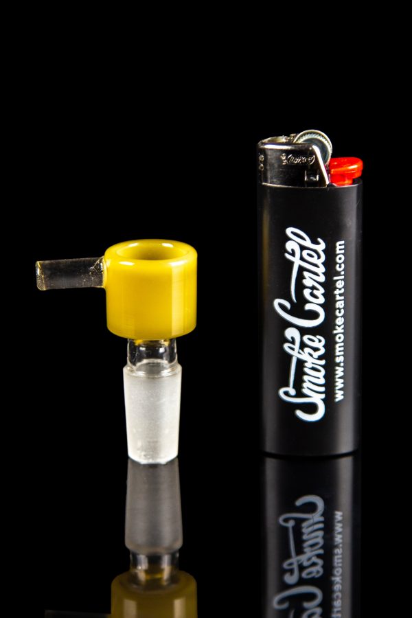 Yellow glass cannabis bowl next to a black lighter with “Smoke Cartel” branding.