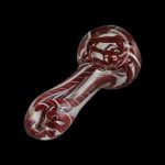 Red and white swirled glass pipe against a black background.
