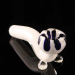 A studio shot displays the White Fritted Sherlock with Black 'Daisy' Fritted Bowl, with a patterned glass bowl and a curved pipe shape.