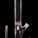 Clear glass bong with purple accents, alongside a downstem and ash catcher.