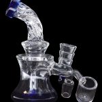 Clear glass rig with attachments, used for concentrated cannabis consumption.