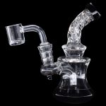 Clear glass dab rig with quartz banger, isolated on black.