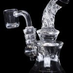 Clear glass dab rig with quartz banger, isolated on black.