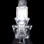 Clear glass dab rig with intricate swirling design, isolated on a black background.
