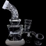Clear glass rig with multiple chambers and accessories against a black background.