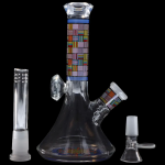 Glass water pipe (bong) with colorful geometric patterns and accompanying glass downstem and bowl, isolated on a black background.