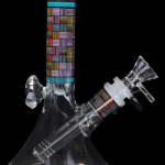 Glass water pipe (bong) with colorful geometric patterns against a black background.