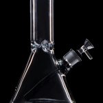 Clear glass bong with a green mouthpiece against a black background.