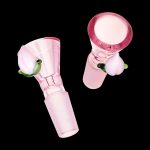 Pink glass bowl piece with green accents, isolated on a black background.