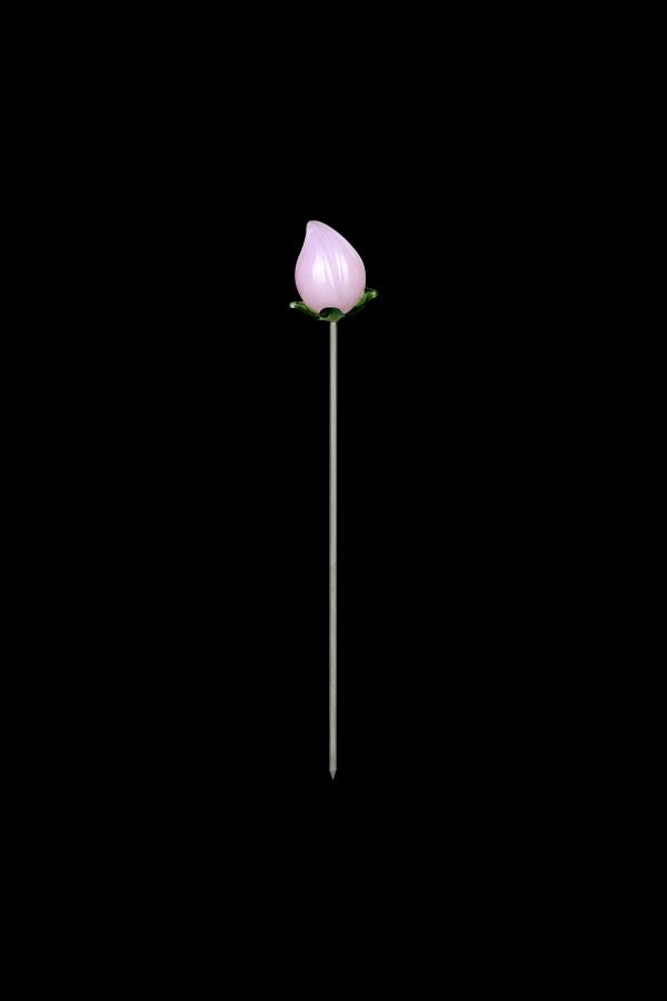 Pink glass cannabis oil burner tip on a thin metal stem against a black background.