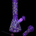 Purple glass water pipe and bowl with strawberry pattern, studio shot.