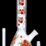 A glass bong decorated with red roses, alongside a glass downstem and bowl.