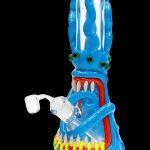 Blue glass water pipe shaped like a monster with sharp teeth and glowing eyes.