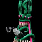 Green glass water pipe shaped like a monster with tentacles and sharp teeth.