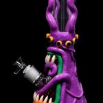 Purple glass bong shaped like a cartoonish octopus with orange claws and a green mouthpiece.