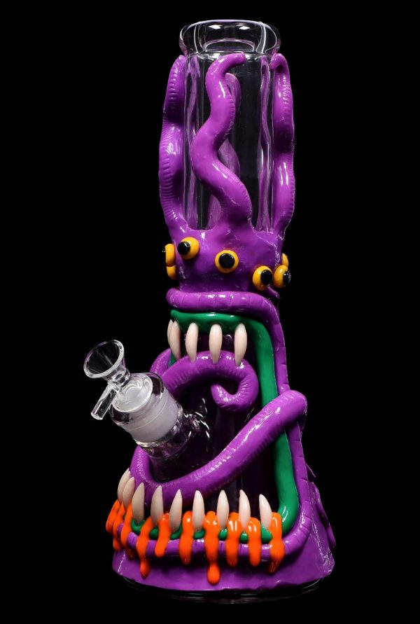A vibrant, sculpted glass water pipe shaped like a monster with tentacles, teeth, and glowing orange accents, against a black background.