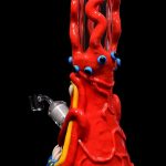 Red glass water pipe shaped like a monster with bulging eyes and colorful tentacles.