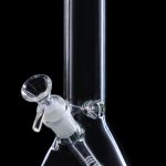 Clear glass bong with a green mouthpiece and intricate glass detailing.