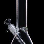 Clear glass bong with green accents against a black background.