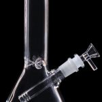 Clear glass bong with a flared base and removable downstem, isolated on a black background.