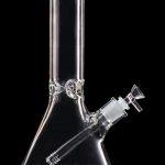 Clear glass bong with a downstem, isolated on a black background.