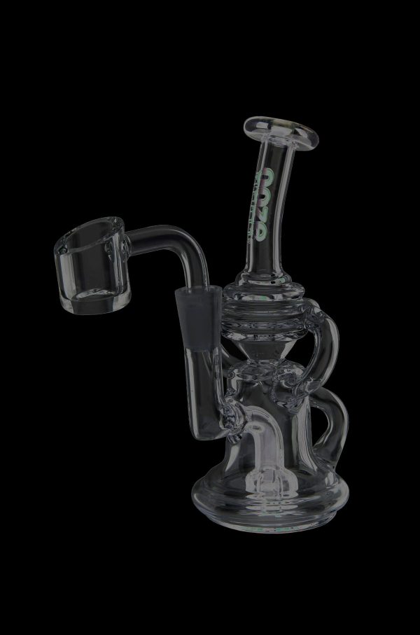 Clear glass dab rig with black accents and a quartz nail, isolated on a black background.