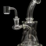 Clear glass dab rig with quartz banger, isolated on a black background.
