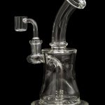 Clear glass dab rig with intricate percolator and quartz nail, isolated on black.